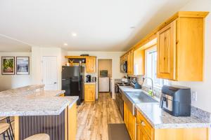 una cucina con armadi in legno e frigorifero nero di Beaver Pines Central Hiking Camp on Budget a Beaver