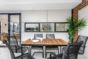 a dining room with a wooden table and chairs at Station & Surf 3BR Wollongong Townhouse in Wollongong