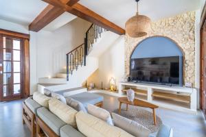 a living room with white furniture and a stone wall at Noa Villa Gili Air in Gili Islands