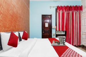 a bedroom with a bed with red and white pillows at Super Hotel O Kiara Villa Matiyari Chauraha Chinhat Bus Stop in Chinhat +20 photos