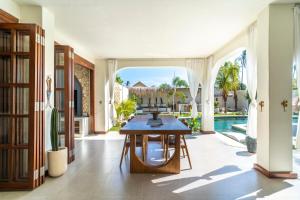 a dining room with a table and a pool at Noa Villa Gili Air in Gili Islands