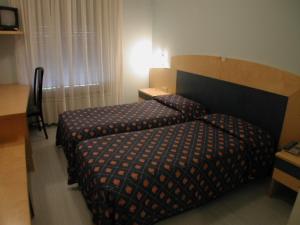 Hotel Palladio في San Fior di Sopra: غرفة في الفندق مع سرير ومكتب