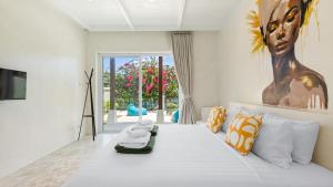 a bedroom with a large bed with a statue of a africa at Aqua Vista 02 - 4BR Villa Near the Beach in Amphoe Koh Samui