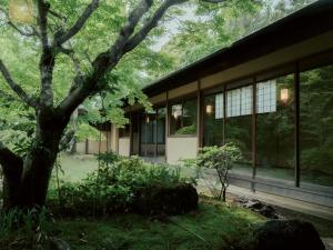 a building with a tree in front of it at Sanyo-so in Izunokuni
