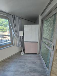 a room with a large window and a dresser at 인천공항 인근 여행자 숙소 in Incheon