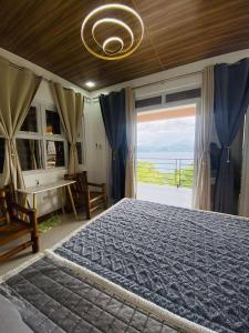 a bedroom with a large bed with a large window at CJ's Place Mabini in Mabini