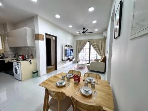 a kitchen and living room with a wooden table and chairs at Danga Bay The Balcony Coast 2BR 4 Pax w Mahjong by Our Stay in Johor Bahru
