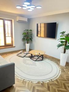 a living room with a table and two potted plants at Apartment lux in Samarkand