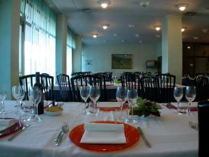 a table with a white table cloth and wine glasses at Hotel Palladio in San Fior di Sopra
