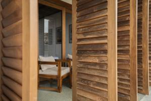 a room with a wooden wall and a chair at Marshmallow Bay Boutique Hotel & Surf Point Adults Only in Ahangama