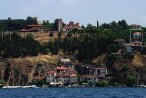 un groupe de maisons sur une colline à côté de l'eau dans l'établissement Maslov Apartments, à Ohrid