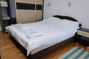 a bed with white sheets and towels on it at Maslov Apartments in Ohrid