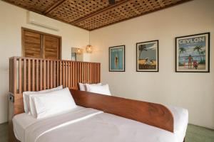 a bedroom with a large bed with a wooden headboard at Marshmallow Bay Boutique Hotel & Surf Point Adults Only in Ahangama