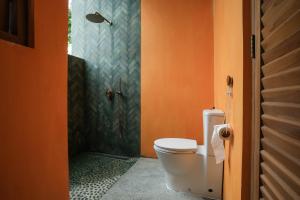 an orange bathroom with a toilet and a shower at Marshmallow Bay Boutique Hotel & Surf Point Adults Only in Ahangama