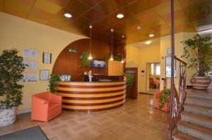 a woman standing at a counter in a lobby at Aparthotel Pineda in Bibione