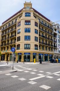 a large yellow building on a city street with a road at Pension Kursaal in San Sebastián
