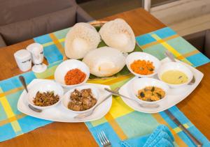 a table with bowls and plates of food on it at Funk Bunks - Sigiriya in Sigiriya