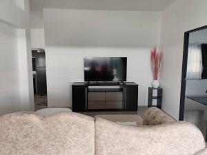 a living room with a couch and a flat screen tv at Pattiya House in Hua Thanon Beach