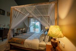 een slaapkamer met een hemelbed en een raam bij Turtle Nest in Tangalle