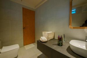 een badkamer met een wit toilet en een wastafel bij Turtle Nest in Tangalle
