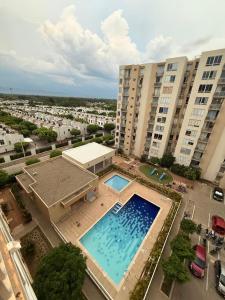 an overhead view of a large swimming pool in front of buildings at Apartamento súper dotado con aire acondicionado in Valledupar