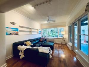 Cozy Beachside 5BR Home with Pool & Rumpus & King beds في ملبورن: غرفة معيشة مع أريكة ونافذة +25 صورة