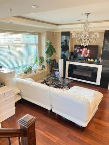 Una sala de estar con un sofá blanco y una chimenea. en Cozy stay in Cental Vancouver, en Vancouver