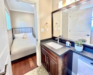 Un baño con lavabo, espejo y cama. en Cozy stay in Cental Vancouver, en Vancouver