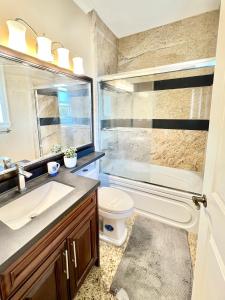 Un baño con lavabo, ducha e inodoro. en Cozy stay in Cental Vancouver, en Vancouver