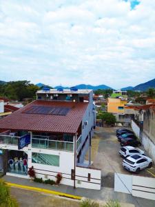 a building with cars parked in a parking lot at Pousada Papito Ubatuba - Praia Perequê-Açu in Ubatuba +35 photos