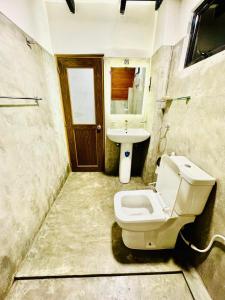 a bathroom with a toilet and a sink at Dreamers Den in Nuwara Eliya