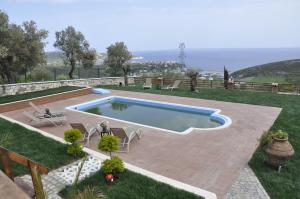 a swimming pool in a yard with chairs at Taş Avlu Butik Otel in Karaburun