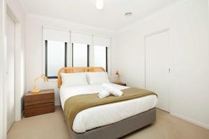 a bedroom with a bed with a towel on it at Northside Townhouse Geelong in Norlane
