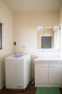 a bathroom with a white refrigerator and a sink at Gray House Toya in Lake Toya
