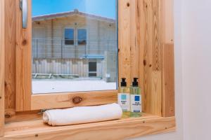 a window with a towel and two bottles on a shelf at Cabañas de Allariz - Cabaña 3 in Allariz