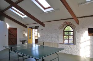 a ping pong table in a room with a stone wall at Ardtarmon House in Sligo