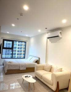a living room with a bed and a couch at Honey Vinhomes in Long Bình