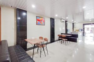 a dining room with a table and chairs in a room at RedDoorz at Rejoss Lux Medan in Medan