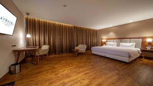 a hotel room with a bed and a desk and chair at Avenzel Hotel & Convention Cibubur in Cibubur +78 photos