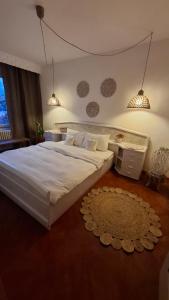 1 dormitorio con 1 cama blanca grande y 1 alfombra en Boho Chic Apartament, en Reghin