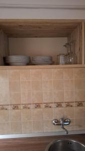 una encimera de cocina con platos en un estante sobre un fregadero en Boho Chic Apartament, en Reghin