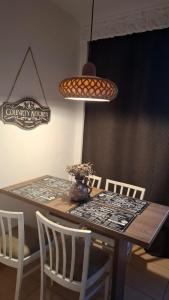 Una mesa de comedor con sillas blancas y una mesa de centro. en Boho Chic Apartament, en Reghin