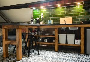 a kitchen with a counter and a green wall at Luxe loft in vierkantshoeve in Sint-Truiden