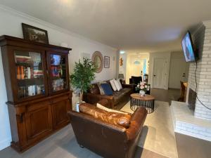 ein Wohnzimmer mit Ledersofa und Fernseher in der Unterkunft LF Guesthouse in Nanaimo
