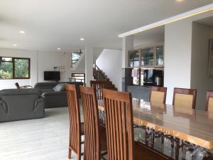 a dining room and living room with a table and chairs at Dwell Guesthouse Dago in Ciburial