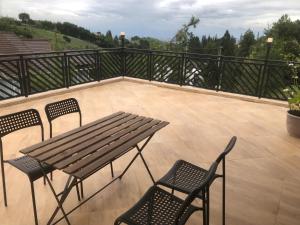 a patio with a wooden table and chairs on a balcony at Dwell Guesthouse Dago in Ciburial