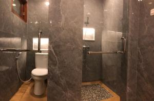 a bathroom with a toilet and a glass shower at Dwell Guesthouse Dago in Ciburial