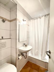 a bathroom with a sink and a toilet and a shower at Barcelona Bed & Breakfast in Düsseldorf