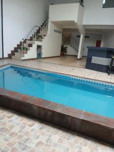 una gran piscina con agua azul y escaleras en Hotel Capibara, en Iquitos