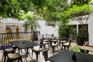a patio with tables and chairs and plants at La Rose Suites in Phnom Penh